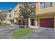 Townhome exterior with well-kept landscaping, garages, and visible unit numbers at 5601 Bentgrass Dr # 10-115, Sarasota, FL 34235