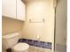 Bathroom with white toilet, cabinet and shower, accented with blue tile and neutral walls at 5638 Garden Lakes Palm, Bradenton, FL 34203