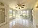 Bright sunroom with tiled flooring, ceiling fan, and glass windows offering a serene outdoor view at 5638 Garden Lakes Palm, Bradenton, FL 34203