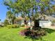 Well-maintained home with a lush lawn, mature landscaping, and an attached garage at 5638 Garden Lakes Palm, Bradenton, FL 34203