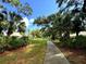 Scenic walking path through a lush, tree-lined community under a clear blue sky at 5638 Garden Lakes Palm, Bradenton, FL 34203