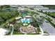 Aerial view of community pool, tennis courts, lush landscaping, and parking area at 5734 Archipelago St, Nokomis, FL 34275
