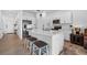 Bright kitchen with stainless steel appliances, white cabinetry, quartz countertops, and seating at the island at 5734 Archipelago St, Nokomis, FL 34275