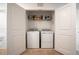 Convenient laundry closet with a washer, dryer, shelving, and bi-fold doors at 5734 Archipelago St, Nokomis, FL 34275