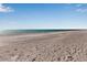 Picturesque sandy beach with calm waters under a blue sky, offering a serene and inviting coastal landscape at 5757 Gulf Of Mexico Dr # 110, Longboat Key, FL 34228