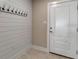 Bright entryway featuring a stylish coat rack against a modern shiplap wall, next to the front door at 5757 Gulf Of Mexico Dr # 110, Longboat Key, FL 34228
