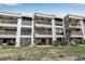 Multi-story condo building featuring private balconies with ceiling fans, surrounded by lush tropical landscaping at 5757 Gulf Of Mexico Dr # 110, Longboat Key, FL 34228
