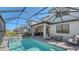 An expansive screened-in pool with a summer kitchen, chairs, and a spa at 6144 Baywood Ct, Bradenton, FL 34211