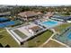 Aerial view of community amenities showcasing pool, tennis courts, and clubhouse with lush landscaping at 618 Bird Bay S Dr # 118, Venice, FL 34285