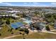 Aerial view of community with tennis courts, pool, and clubhouse surrounded by green space at 618 Bird Bay S Dr # 118, Venice, FL 34285