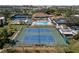 Aerial view of community amenities including swimming pool and tennis courts amid mature trees at 618 Bird Bay S Dr # 118, Venice, FL 34285
