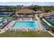 Aerial view of the community pool area featuring lounge chairs, sun umbrellas and tables at 618 Bird Bay S Dr # 118, Venice, FL 34285