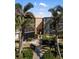 Exterior view of Sandpiper condo unit with mature landscaping, screened balconies, and walkways at 618 Bird Bay S Dr # 118, Venice, FL 34285