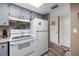 Kitchen featuring standard appliances, wood-look floors, and a side entrance at 618 Bird Bay S Dr # 118, Venice, FL 34285