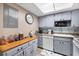 Galley-style kitchen with a butcher block counter, blue accent backsplash, and grey cabinetry at 618 Bird Bay S Dr # 118, Venice, FL 34285