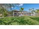 Sprawling backyard with manicured lawn showcases large screened in pool and comfortable outdoor seating at 618 Buttonwood Dr, Longboat Key, FL 34228