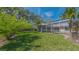 Backyard with well-manicured lawn, a screened in patio, and mature trees at 618 Buttonwood Dr, Longboat Key, FL 34228