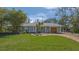 Well-maintained home exterior with a green lawn, beautiful trees, and brick driveway at 618 Buttonwood Dr, Longboat Key, FL 34228