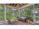 Covered outdoor living space features cozy seating within a screened in lanai and beautiful landscaping at 618 Buttonwood Dr, Longboat Key, FL 34228