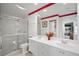 Bright bathroom featuring double sinks, a glass shower, and red accent stripe at 7623 Camminare Dr, Sarasota, FL 34238