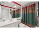 Well-lit bathroom featuring a single sink vanity and shower with a patterned curtain at 7623 Camminare Dr, Sarasota, FL 34238