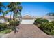 Charming single-story home featuring a two-car garage and a well-maintained, lush green lawn at 7623 Camminare Dr, Sarasota, FL 34238