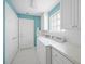 Bright laundry room with tile floors, a utility sink, and white washer and dryer at 7623 Camminare Dr, Sarasota, FL 34238