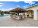 Inviting poolside tiki bar with seating, perfect for relaxation and entertainment at 7623 Camminare Dr, Sarasota, FL 34238