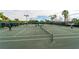 Active tennis courts with players, green courts, and lighting offer a recreational community amenity at 7623 Camminare Dr, Sarasota, FL 34238