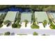 Aerial view of the townhome with a green roof, lush landscaping, and a serene lake in the background at 8536 54Th Avenue E Cir, Bradenton, FL 34211