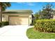 Charming front exterior with a well-manicured lawn, colorful landscaping, and attached two-car garage at 8536 54Th Avenue E Cir, Bradenton, FL 34211
