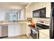 Efficient kitchen with stainless steel appliances, white cabinets, and a view to the open living area at 8536 54Th Avenue E Cir, Bradenton, FL 34211