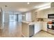 Open-concept kitchen with white cabinets, stainless steel appliances, and wood-look tile flooring at 8536 54Th Avenue E Cir, Bradenton, FL 34211