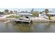 Home with a boat dock on the canal with a covered lift, and boat, and lush landscaping at 928 Spindle Palm Way, Apollo Beach, FL 33572