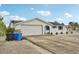 Charming single-story home with a two-car garage, neutral paint scheme, and a row of potted plants in front of the windows at 928 Spindle Palm Way, Apollo Beach, FL 33572