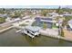 Waterfront home featuring a boat lift, screened pool, solar panels, and a grassy yard at 928 Spindle Palm Way, Apollo Beach, FL 33572