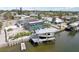 Waterfront home featuring a boat lift, screened pool, solar panels, and tropical landscaping at 928 Spindle Palm Way, Apollo Beach, FL 33572