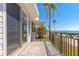 Relaxing outdoor balcony with black metal railing, with palm trees and a picturesque view of the water at 10315 Cortez W Rd # 38Bv, Bradenton, FL 34210