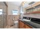 Bathroom featuring a glass shower, vanity with dark countertop, and neutral-toned tile at 10315 Cortez W Rd # 38Bv, Bradenton, FL 34210