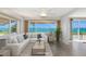 Bright living room features a large white sectional sofa with many large windows and a panoramic waterfront view at 10315 Cortez W Rd # 38Bv, Bradenton, FL 34210