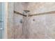 Tiled shower featuring a showerhead, shelving, and decorative accents at 10315 Cortez W Rd # 38Bv, Bradenton, FL 34210