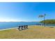 Scenic waterfront view featuring bench seating and lush palm trees against a clear blue sky at 10315 Cortez W Rd # 38Bv, Bradenton, FL 34210