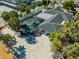 Aerial view of home featuring a screened-in pool, paved driveway, lush landscaping, and a well-maintained exterior at 106 N Blvd Of The Presidents, Sarasota, FL 34236