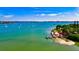 A scenic view of the ocean, a sandy shore, and an island restaurant under a partly cloudy sky on a sunny day at 106 N Blvd Of The Presidents, Sarasota, FL 34236