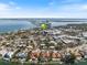 An aerial view of a waterfront community with single Gathering homes with docks, a city, and a bridge in the background at 106 N Blvd Of The Presidents, Sarasota, FL 34236