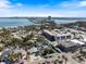 An aerial view of a single-Gathering home near commercial buildings, the ocean, and a bridge in the distance on a sunny day at 106 N Blvd Of The Presidents, Sarasota, FL 34236