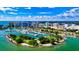An aerial view of waterfront homes near a marina, luxury high-rise buildings, and lush landscaping on a sunny day at 106 N Blvd Of The Presidents, Sarasota, FL 34236