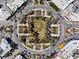 An overhead view of a traffic circle, landscaped square, and retail businesses in a city with palm trees at 106 N Blvd Of The Presidents, Sarasota, FL 34236