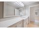 Bright bathroom with a quartz countertop, white cabinets, and a large framed mirror at 106 N Blvd Of The Presidents, Sarasota, FL 34236