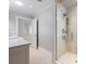 Bathroom featuring a glass shower, dual sinks, and neutral color palette at 106 N Blvd Of The Presidents, Sarasota, FL 34236